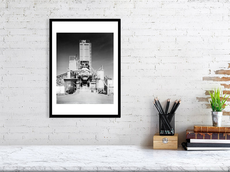 Black and white photograph of an industrial structure displayed in a styled interior desktop setting (mockup)