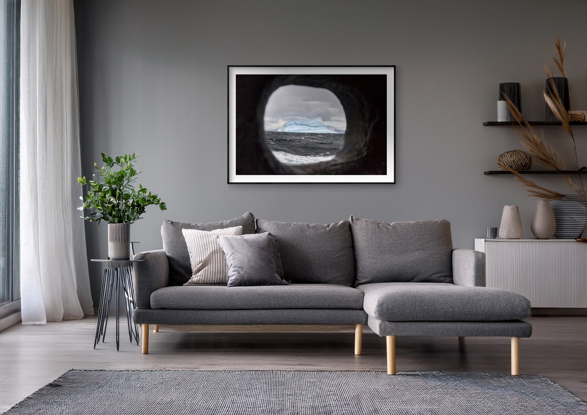 Colour photograph of an iceberg viewed through a ship’s scupper, displayed in a styled interior setting (mockup)
