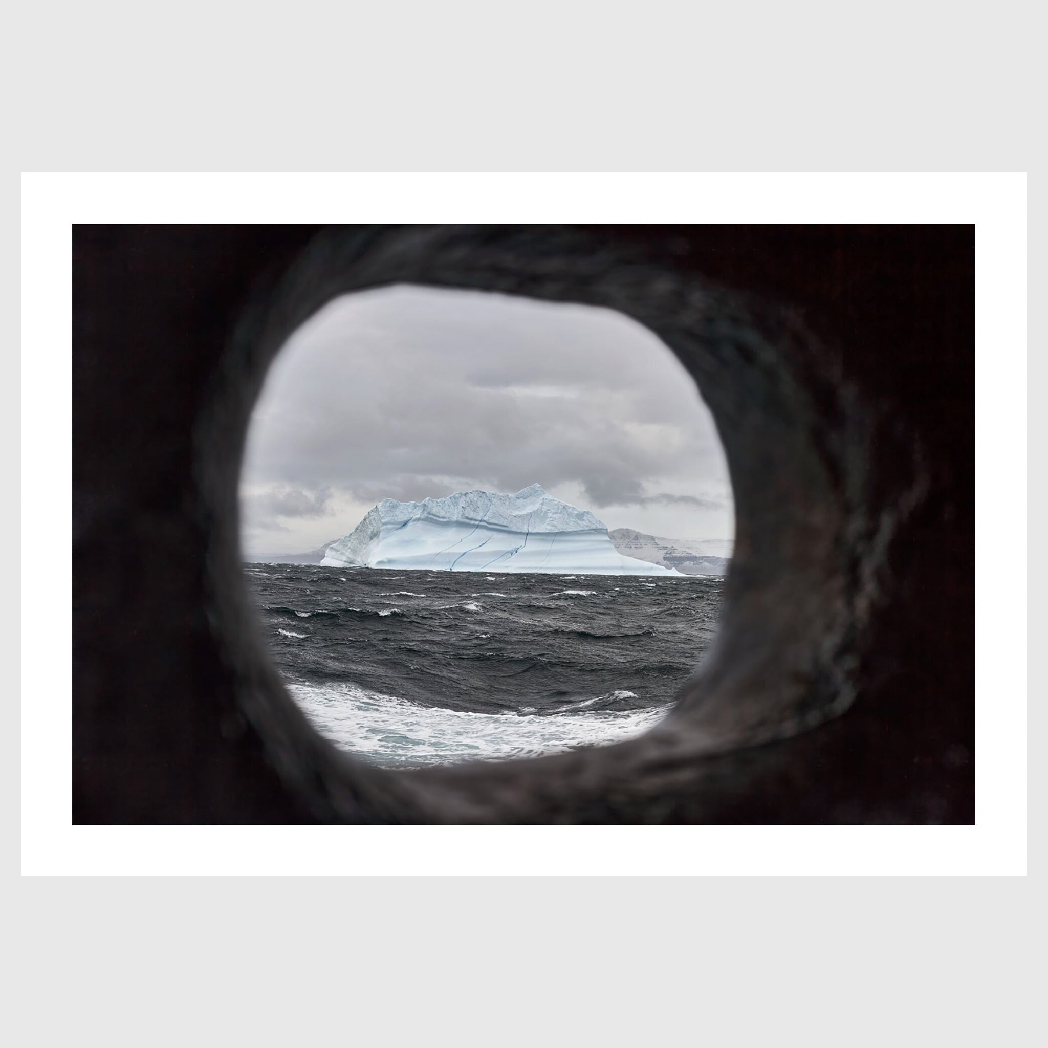 
Colour photograph of an iceberg viewed through a ship’s scupper, Greenland