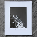 One-off black and white darkroom photograph of a hotel rooftop sign and palm tree against a cloudless sky, hand-printed by the artist.