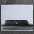 One-off black and white darkroom photograph of a freight train in a rural landscape, hand-printed by the artist.