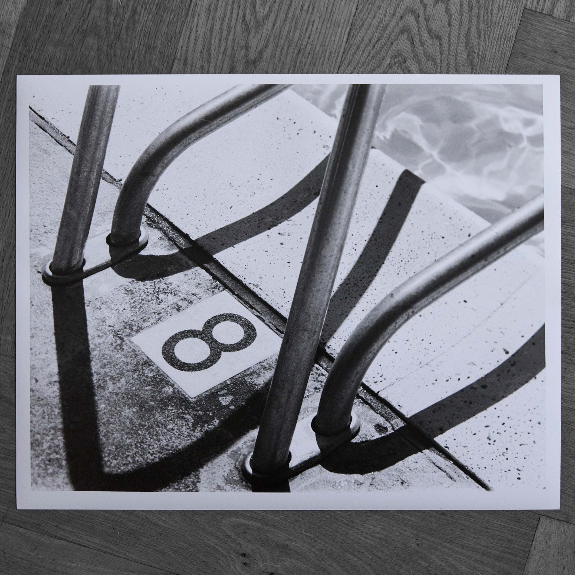 One-off black and white darkroom photograph of a swimming pool ladder and 8 marking, hand-printed by the artist.