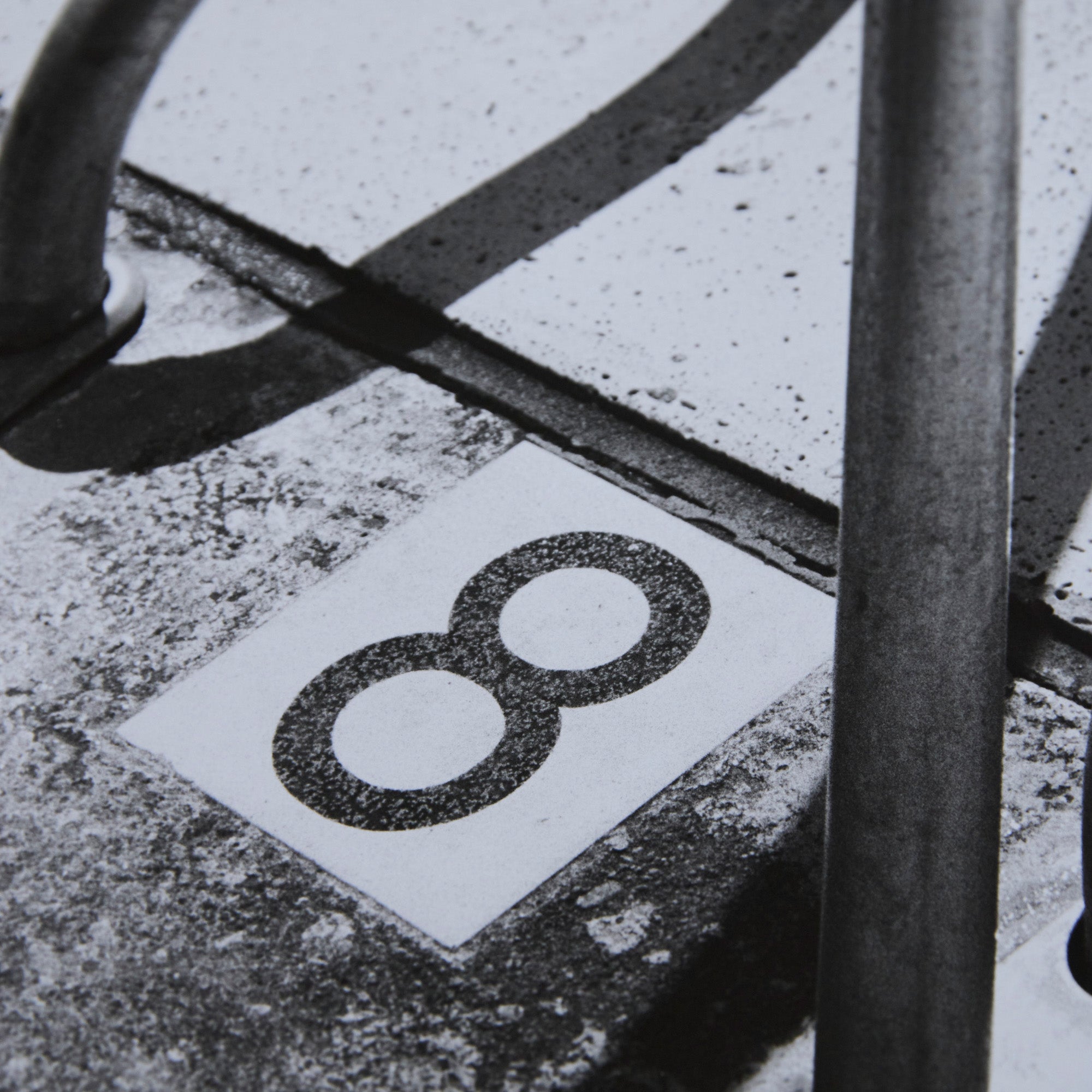 Detail of a one-off black and white darkroom photograph of a swimming pool ladder and 8 marking, hand-printed by the artist.