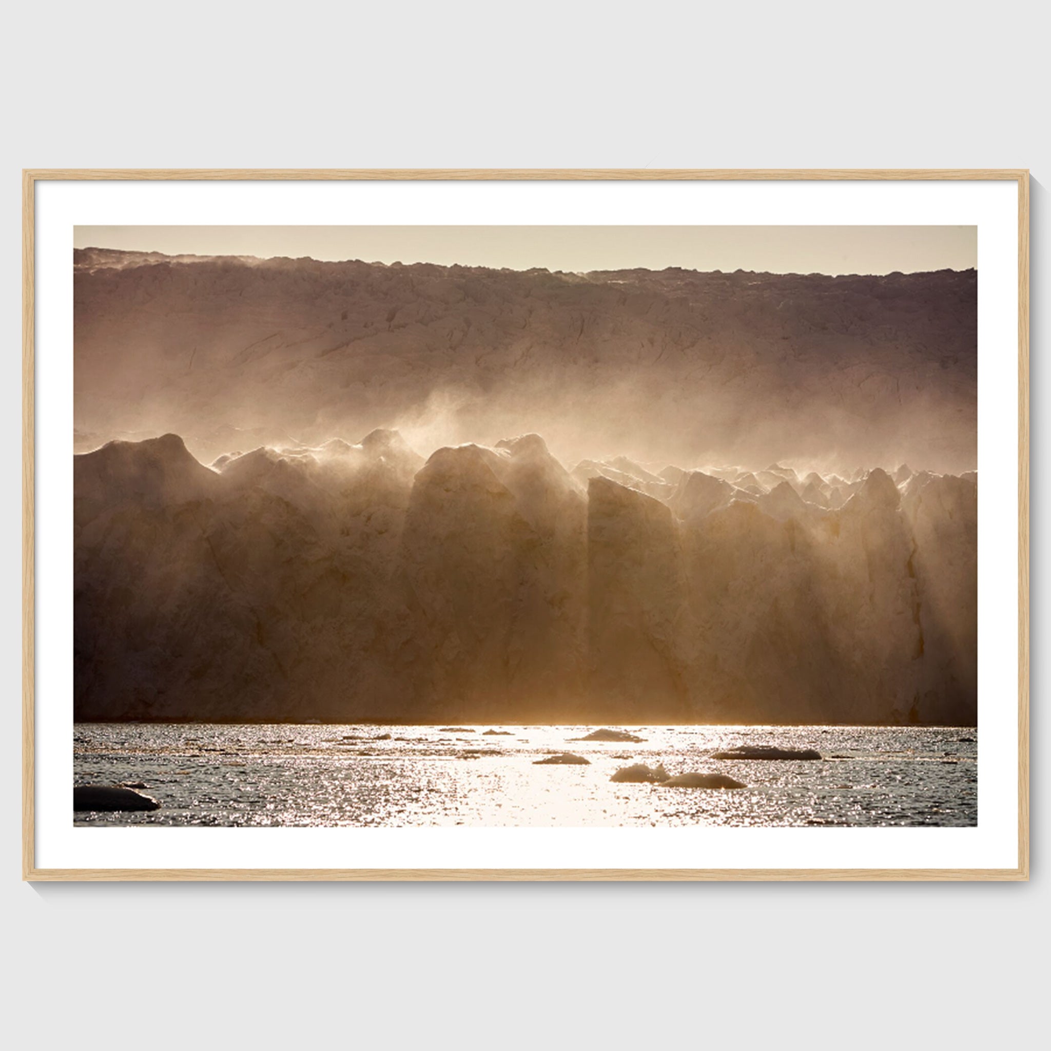Colour photograph of wind-blown ice formations along a glacier wall, shown in an oak frame, Greenland