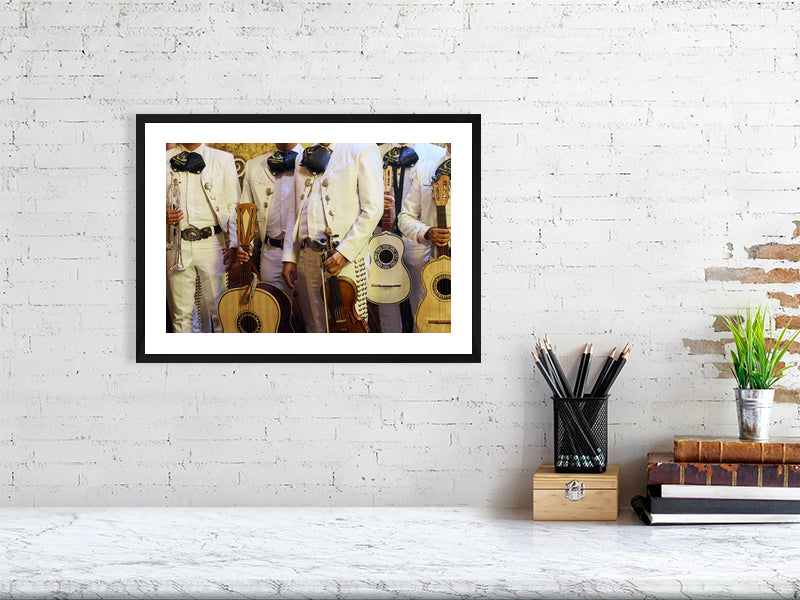Colour photograph of mariachi musicians displayed as a small framed print in a styled interior desktop setting (mockup)