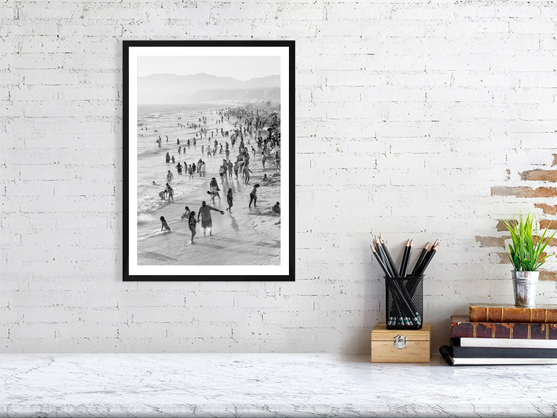Black and white photograph of a beach scene displayed in a styled interior desktop setting (mockup)