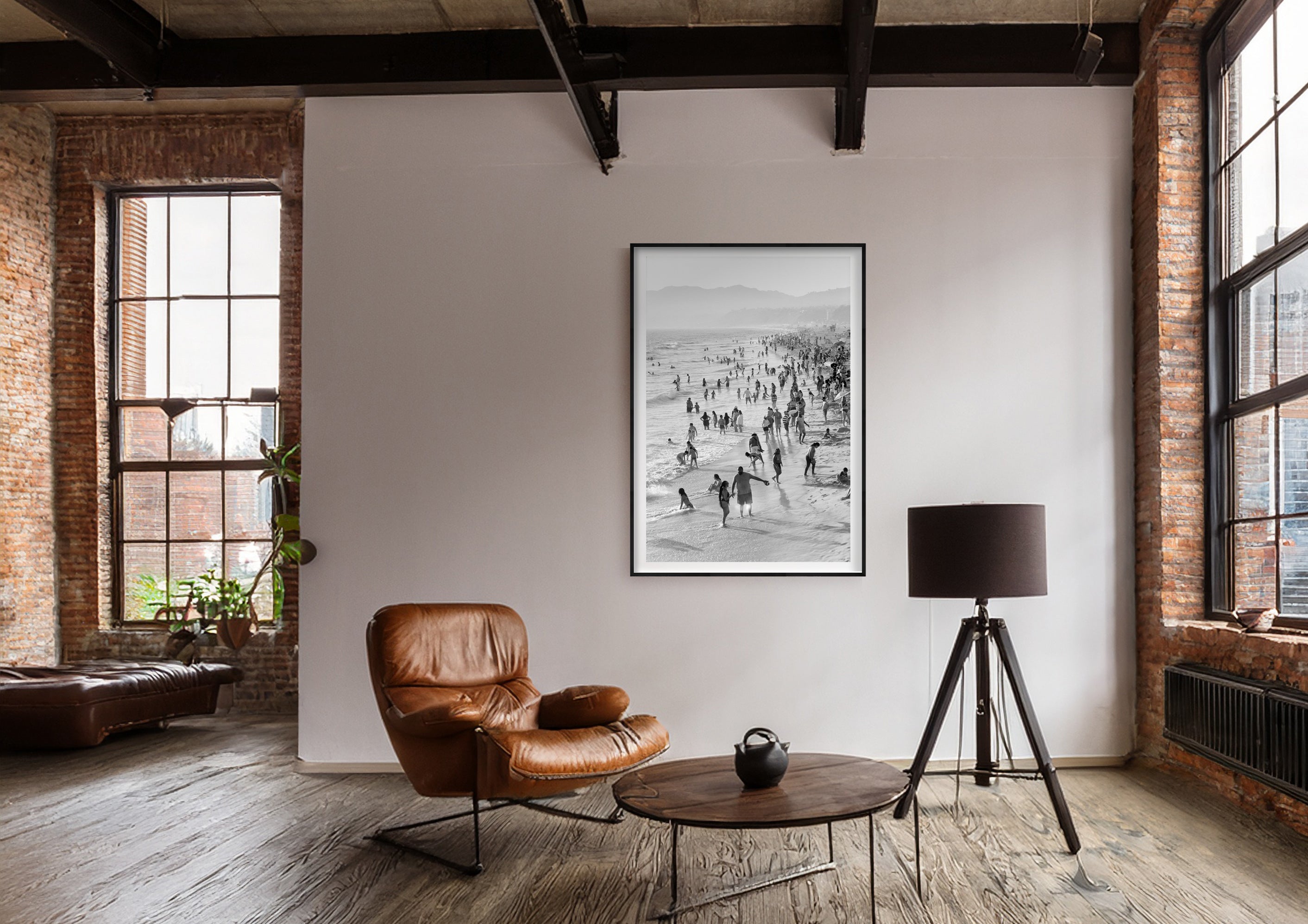 Black and white photograph of a beach scene displayed in a styled interior setting (mockup)