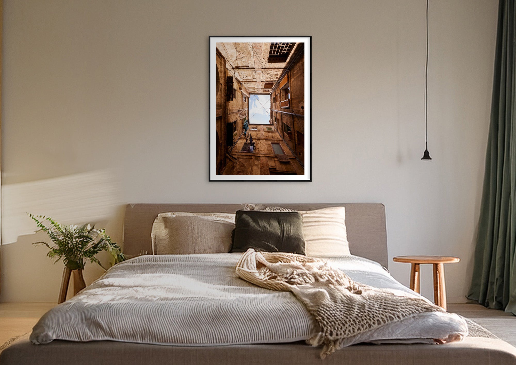 Colour photograph of a Siena courtyard displayed as a large framed print in a styled interior setting (mockup)